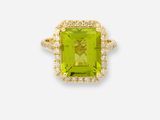 gros plan d'une bague avec une pierre verte entourée de diamants
