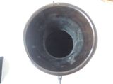 a black vase with a hole in it on a table