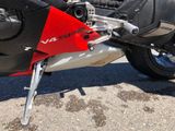 a red and black motorcycle parked in a parking lot
