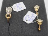 two gold and diamond earrings with tags attached to them
