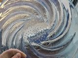a person holding a glass plate with a swirl design on it