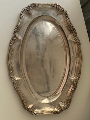 a silver plate on a table with a mirror on it
