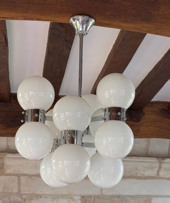 un lustre composé de boules de verre blanc suspendues au plafond