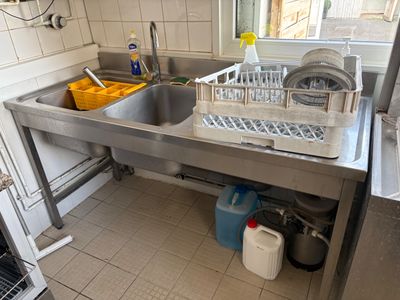 une cuisine équipée d'un évier, d'un lave-vaisselle et d'autres éléments posés sur le plan de travail