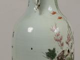 a vase with a painting on it sitting on a table