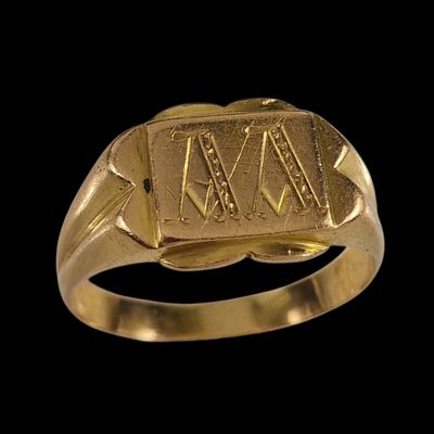 un gros plan d'une bague en or sur laquelle figure un chiffre romain