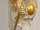 a white and gold statue of a cat on a door