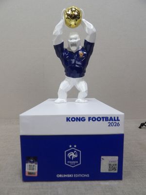 statue d'un homme tenant un trophée de football posé sur une boîte