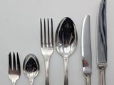 a lot of silverware on a table with a knife and fork