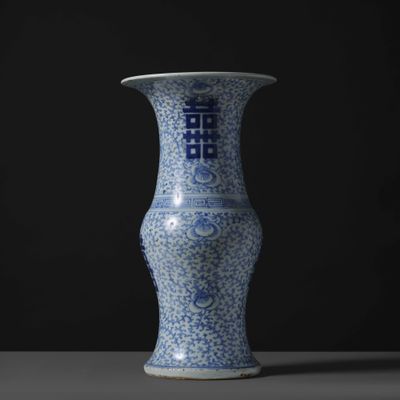 blue and white vase on a table against a black background