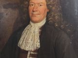 portrait d'un homme vêtu d'un manteau noir et d'une cravate rayée