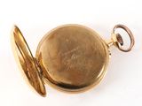 pocket watch on a white surface with a chain around it