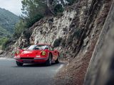 a red sports car driving down a mountain road