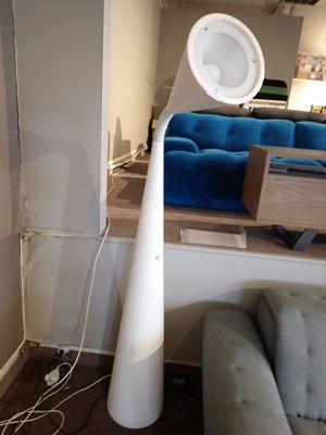 une lampe posée par terre à côté d'un canapé