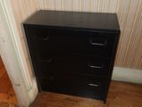 a black filing cabinet in the corner of a room