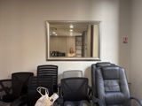 many chairs in a waiting room with a mirror on the wall