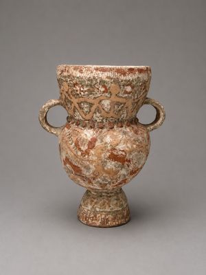 un vase posé sur un socle, sur une surface grise