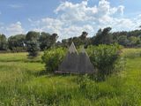 a small triangular structure in the middle of a grassy field