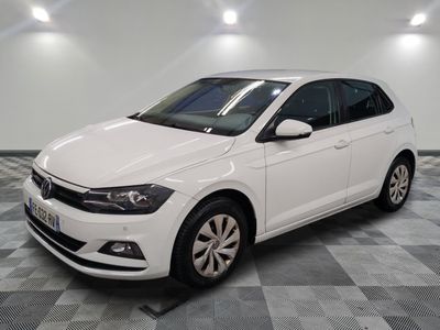 la volkswagen polo blanche est garée dans une pièce au sol à carreaux