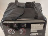the back of a black bag with a black handle on a white surface