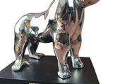 statue of a silver dog on a black base on a white background