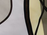 a close up of a white and brown dress with brown trims
