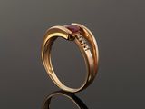 a close up of a gold ring with a ruby stone