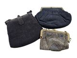 three small purses are lined up on a white surface