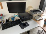 a desktop computer sitting on a desk next to a printer