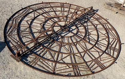 a large metal sundial on the ground in the middle of the day