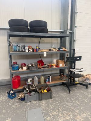 un garage avec une étagère remplie de pneus et d'autres objets