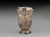 an antique silver cup with a design on the rim