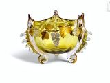 un bol en verre orné de fleurs, posé sur un socle
