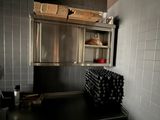 a kitchen with a stove, sink, and shelves in it