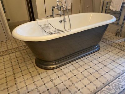 une baignoire au milieu d'un sol carrelé dans une salle de bains
