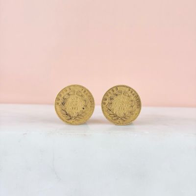 a pair of gold coins sitting on top of a table
