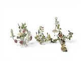 three figurines of birds and flowers on a white surface