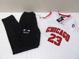 the chicago bulls jersey and pants are laying on a white table
