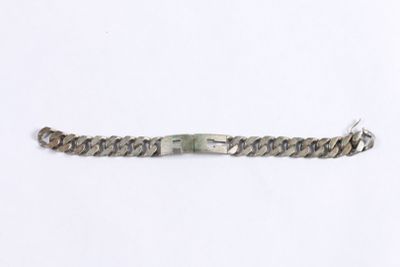 a close up of a metal bracelet on a white surface