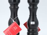 two black pepper grinds with tags on them sitting on a white surface