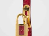 a close up of a red watch with a lock on it