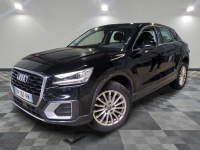 L'Audi QX noire est garée sur un sol en carrelage à damier.