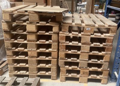 de nombreuses palettes en bois empilées les unes sur les autres dans un entrepôt