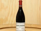 a bottle of wine sitting on top of a barrel