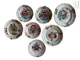 six plates with floral designs are arranged on a white surface