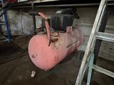 a pink air compressor sitting next to a ladder