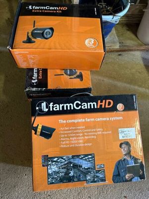 two boxes of farmcam hd cameras sitting on the floor