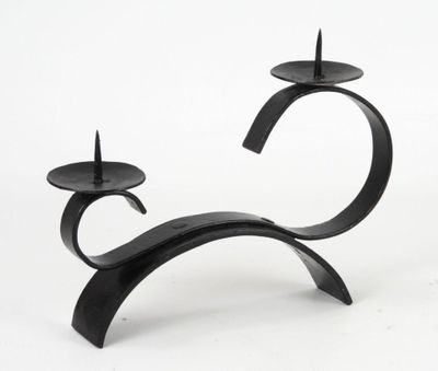 a black candle holder that has two candles on it