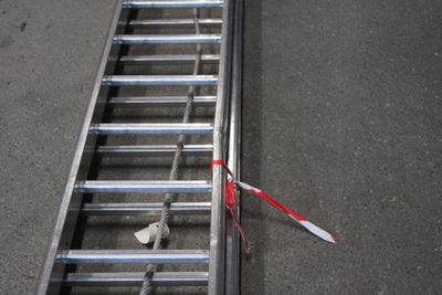 une échelle métallique sur laquelle est posée une paire de ciseaux