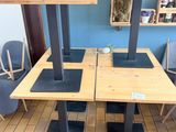 des tables et des chaises dans une pièce aux murs bleus et au parquet